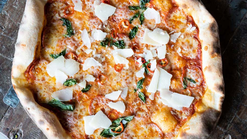 En pizza med parmesan på  och med krispiga kanter
